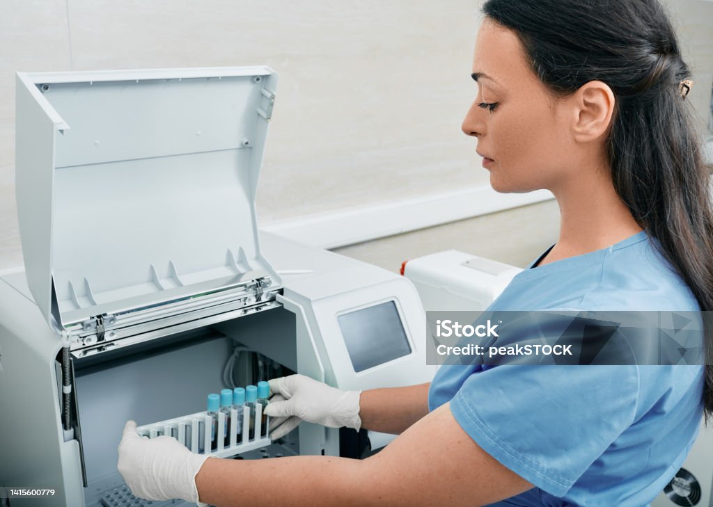Medical Lab Tech Loading Machine Blood Sample Coagulation Analysis Female Laboratory Technician Loading ...