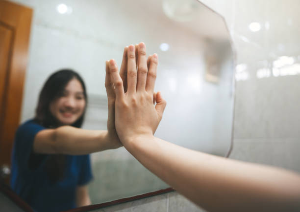 istock Selective focus on hand with blur asian woman practice self talk conversation with mirror in bathroom 1415601669