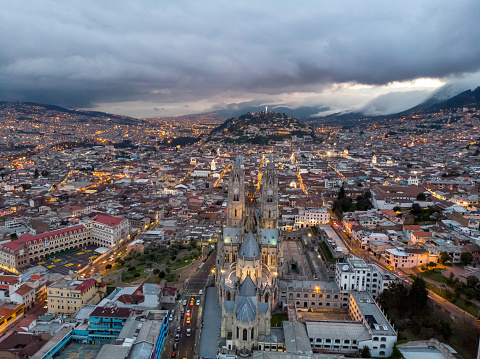 Aerial view of the Basilica of the National Vow, the Panecillo and the colonial Quito with a dramatic sunset