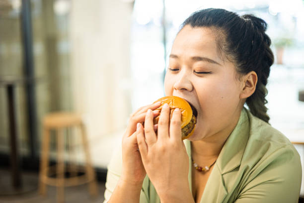 istock Woman eating hamburger 1415604965