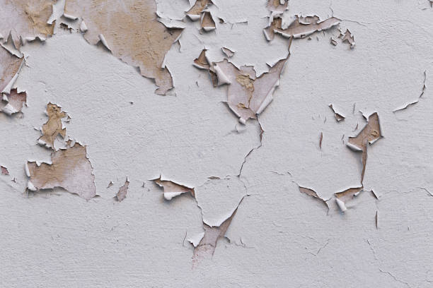 istock Closeup of badly fixed building facade wall covered with cracks in stucco and paint. 1415605962