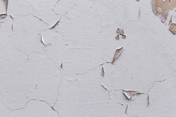 istock Closeup of badly fixed building facade wall covered with cracks in stucco and paint. 1415605966