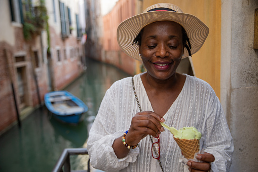 Aa lady eats ice cream while on vacation in Venice, Italy. Mature tourist woman during her trip