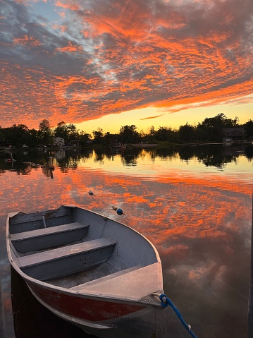 Rowboat and vibrant summer sunset on  Muskoka Lake in Ontario Canada