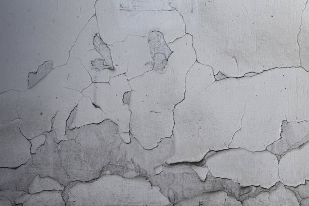 istock Closeup of badly fixed building facade wall covered with cracks in stucco and paint. 1415607201