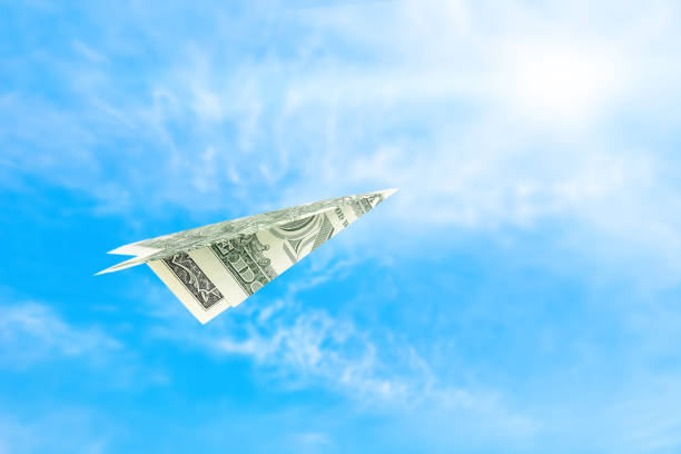 istock Dollar bill plane in the sky 1415607488