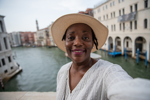A tourist takes a selfie while in Venice during her holidays, woman visiting Italy