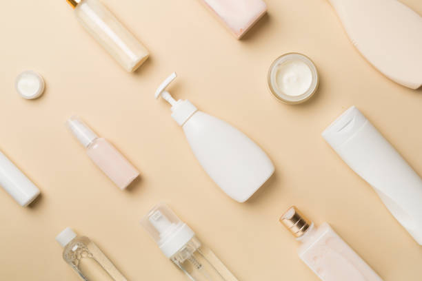 istock Different cosmetic bottles on color background, top view 1415613538
