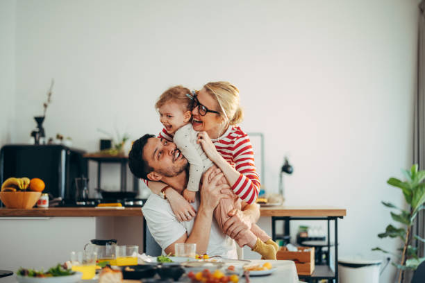 istock Fun at Breakfast: Loving Family of Three Having a Group Hug 1415614352
