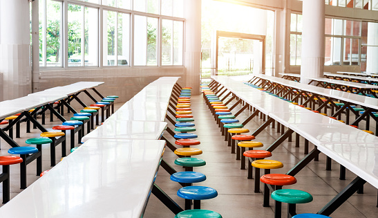 Modern school cafeteria with empty seats and tables