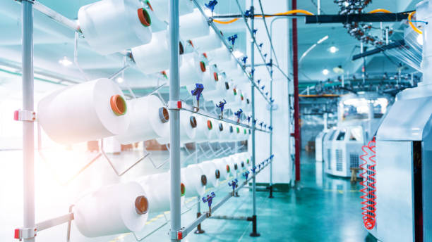 istock Textile industry - yarn spools on spinning machine in textile factory 1415614968