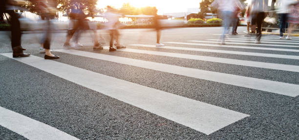 gruppe von menschen, die auf dem zebrastreifen spazieren gehen - crosswalk crowd activity long exposure stock-fotos und bilder