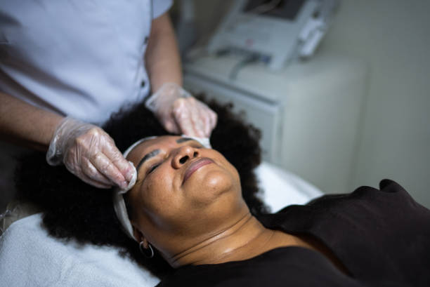 Beautician cleaning customer's skin in a spa Beautician cleaning customer's skin in a spa facial chemical peel stock pictures, royalty-free photos & images