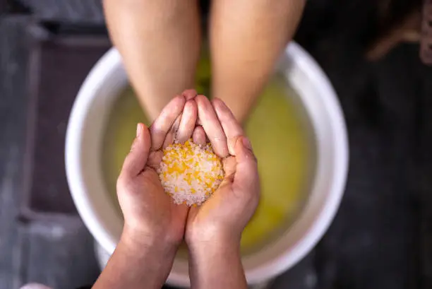 Beautician holding bath salt for a foot bath at a beauty spa