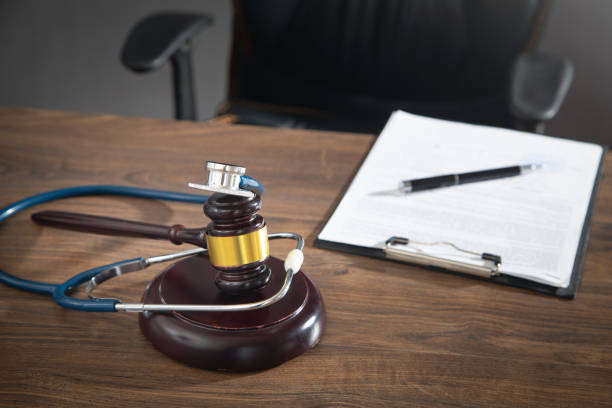 istock Judge gavel, documents and stethoscope on the wooden table. 1415617899