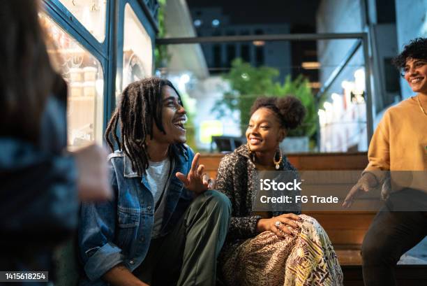 Friends Having Fun Outdoors At Night Stock Photo - Download Image Now - Friendship, Teenager, Talking