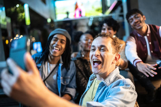 istock Man filming (or taking selfie/video call) using mobile phone with friends enjoying nightlife 1415621000