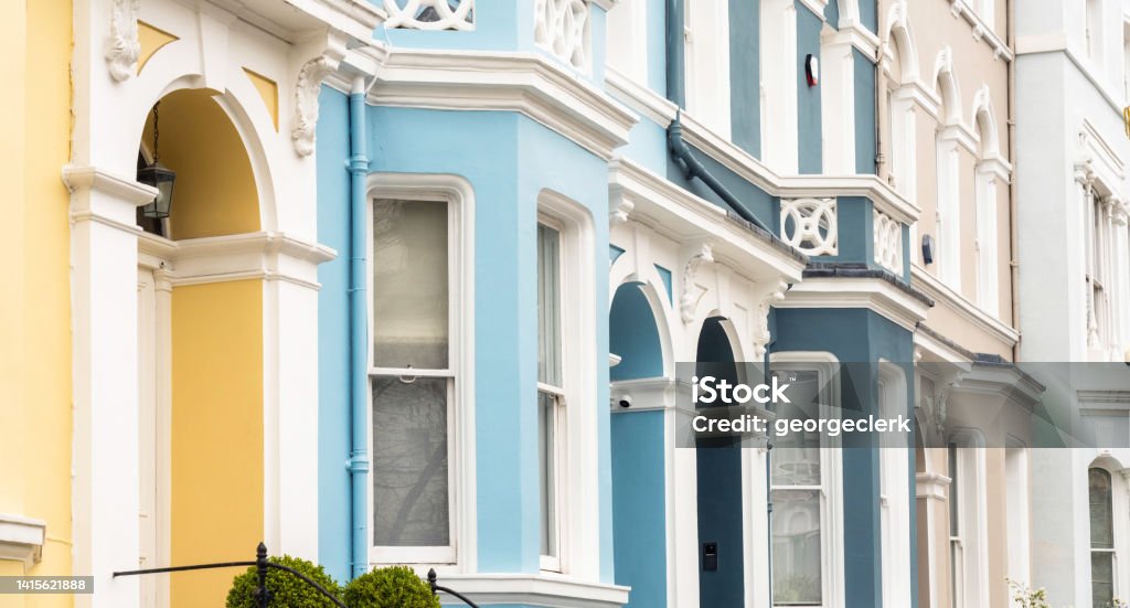 Multi coloured terraced houses in London The front elevations of pastel painted townhouses in Notting Hill, London. Door Stock Photo