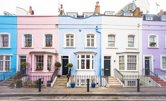 Front view of a row of colourful terraced houses on a side street in London's Chelsea.