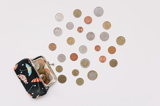 Open purse with different coins isolated on white background top view. Financial crisis, poverty, lack of money