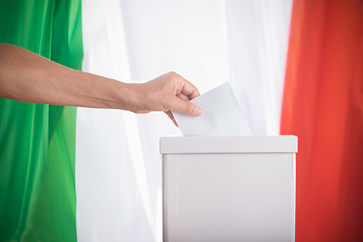 Italian Vote. A close up of a woman hand putting blank ballot in box Democracy concept.