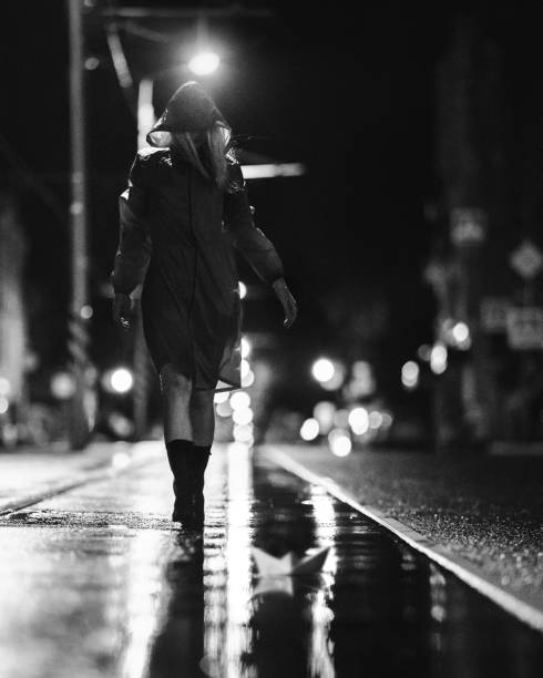 istock Young lady launches a paper boat through the puddles 1415627247