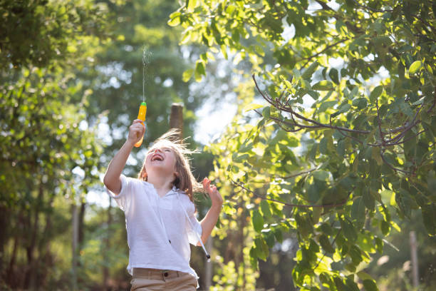 istock Happy boy splashing water with a squirt gun 1415628885