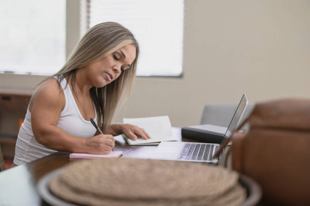 Adult Online Learning A woman with dwarfism using a laptop for online learning at home short stature stock pictures, royalty-free photos & images