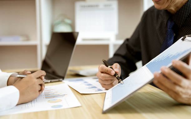 istock Businessman is pointing to a graph to provide information to colleagues 1415630892
