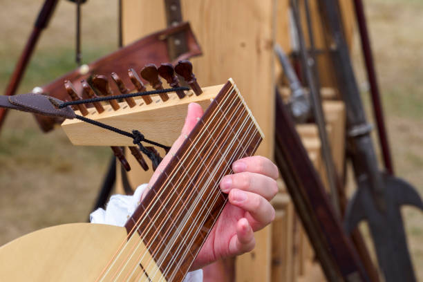 Lviv, Ukraine - May 04, 2025: A man playing bandura musical instrument while seated outdoors in a bustling city in Lviv, Ukraine.