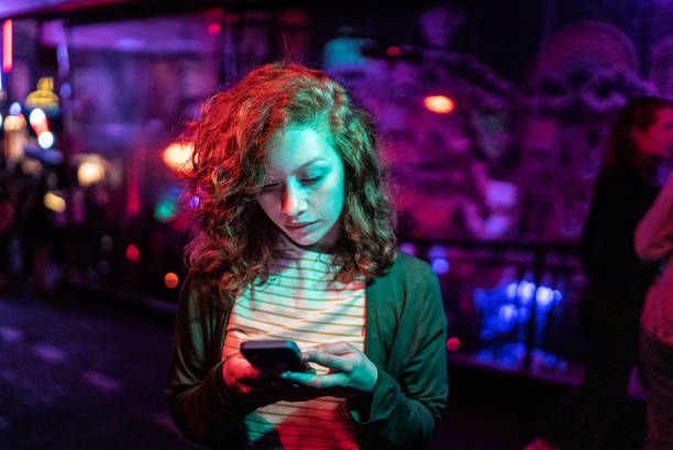 istock Young woman using the mobile phone at nightlife 1415633690