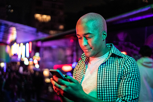 Young man using the mobile phone at nightlife