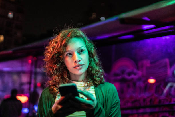 istock Young woman using the mobile phone at nightlife 1415633743