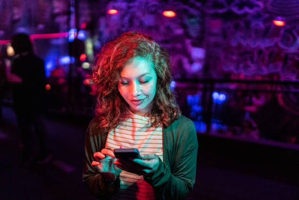 Young woman using the mobile phone at nightlife