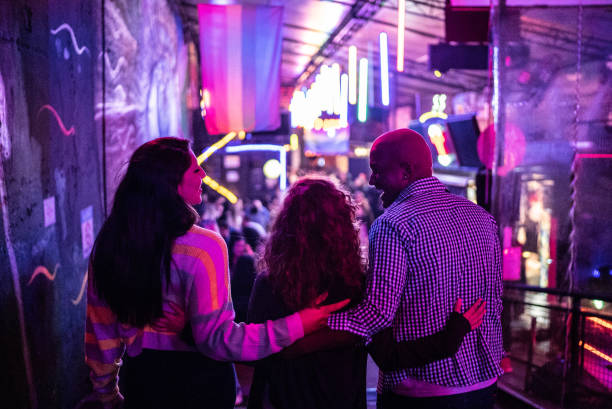 Friends embracing at nightlife - including a transgender person