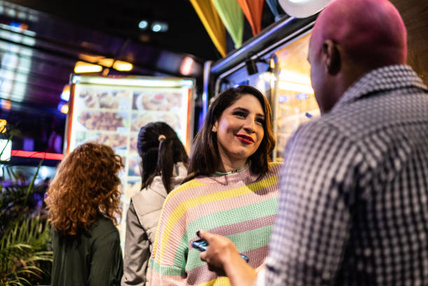 istock Transgender couple (or friends) talking while waiting for food outdoors at night 1415633864