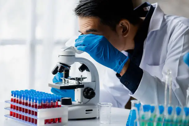 Photo of Laboratory assistants are investigating chemical reactions, medical scientists, chemical researchers, chemical experiments and disease testing from patient blood samples. Medicine and research concept