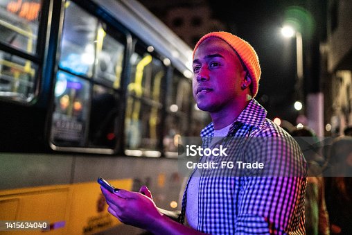 istock Young man using the mobile phone in the street at night 1415634040