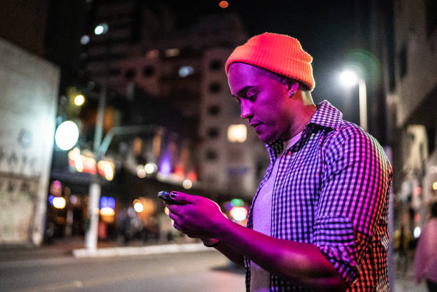 istock Young man using the mobile phone in the street at night 1415634054