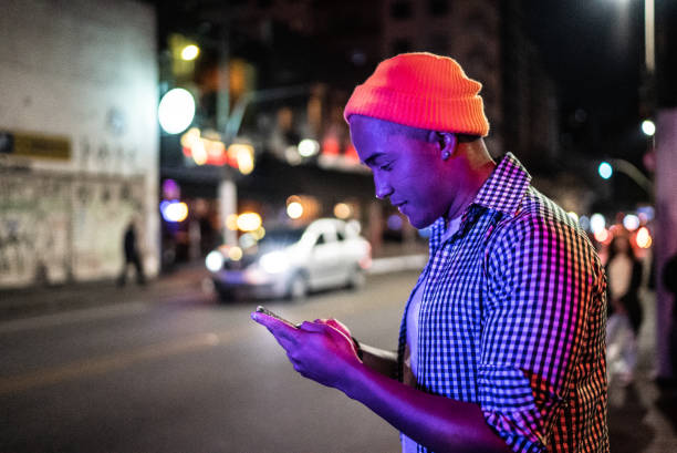 istock Young man using the mobile phone in the street at night 1415634071