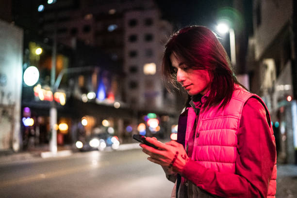istock Young man using the mobile phone in the street at night 1415634192