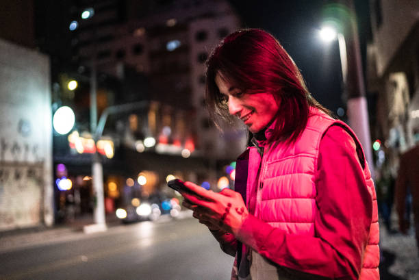 istock Young man using the mobile phone in the street at night 1415634216