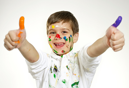 Kid playing with color paints