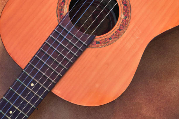 high view, partially showing a guitar, on a brown tile floor. - nylon strings imagens e fotografias de stock