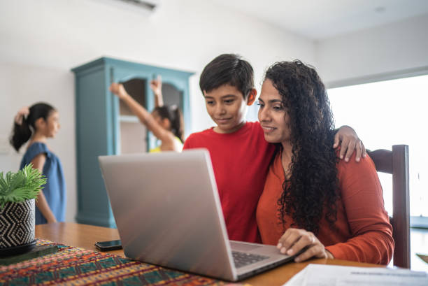 istock Mother and son using laptop at home 1415637345
