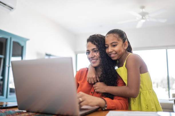 istock Mother and daughter using laptop at home 1415637485