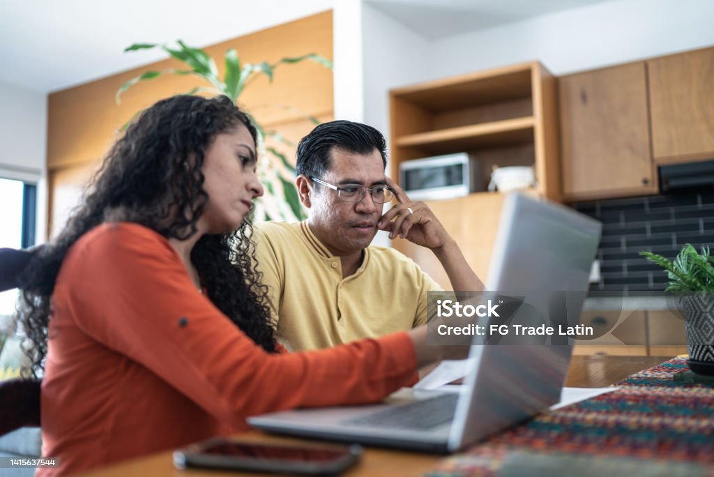 Worried couple using laptop doing home finances Couple - Relationship Stock Photo
