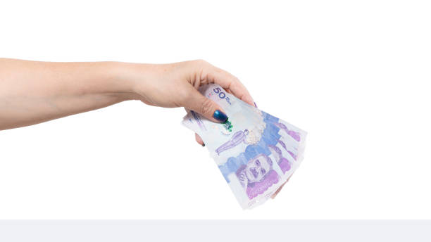 istock woman's hand holding colombia banknotes, isolated on white background 1415638837