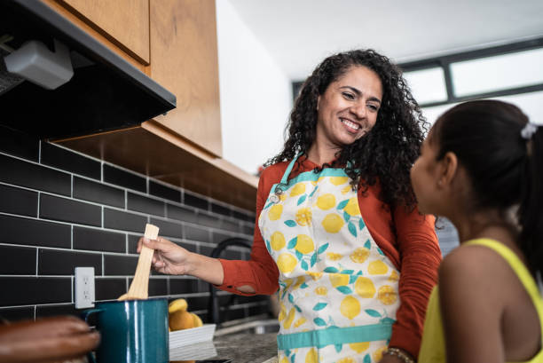 istock Mother and daughter cooking at home 1415639599