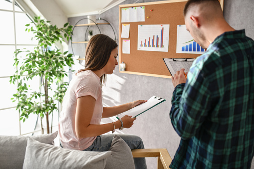 Two Focused Male And Female Students Analyzing School Company Results